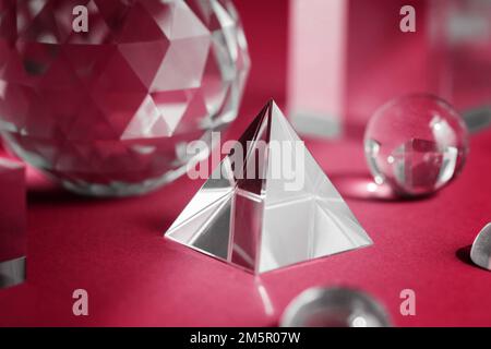 Color of the year 2023 Viva magenta. Crystal prism refracting light, magic crystals and pyramid, sphere and cube on purple background. Spiritual Stock Photo