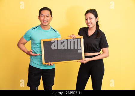 man and woman in sportwear holding blackboard standing Stock Photo