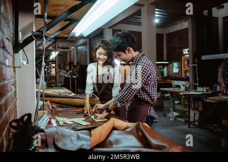 Man and woman tailor working with leather fabric in studio Stock Photo