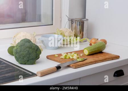 Blur an empty wooden table with fresh vegetables like avocado, onions and marrow to cook, kitchen Stock Photo