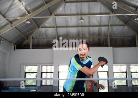 male athlete backhand hitting in a ping pong match Stock Photo