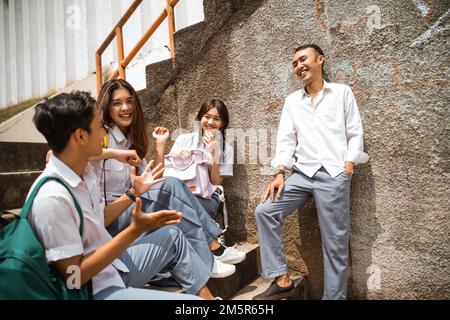High school students in uniforms gather and tell stories Stock Photo