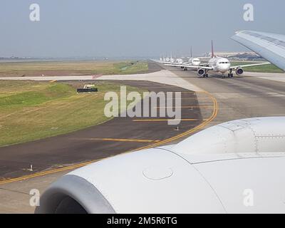 Picture of several airplanes on an airport runway waiting for takeoff clearance at daytime Stock Photo