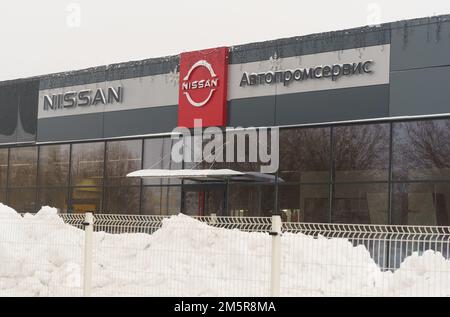 Bobruisk, Belarus, December 17, 2022: Nissan brand logo on the car dealership wall, in winter. Stock Photo