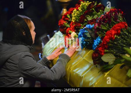 KYIV, UKRAINE - DECEMBER 30, 2022 - A woman grieves at the coffin with the body of former political prisoner Hennadii Afanasiev who died on the front Stock Photo