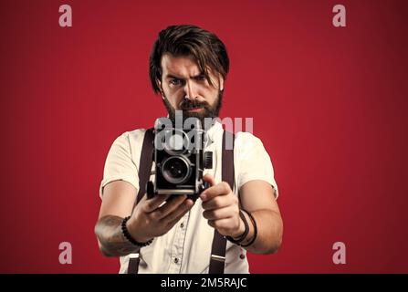 best photographer. handsome hipster making vintage photo. mature journalist use old technology. bearded camera man in suspenders. brutal guy Stock Photo