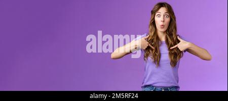 You mean me. Surprised cheerful silly caucasian female student pointing herself impressed astonished choice was picked chosen folding lips excitement Stock Photo