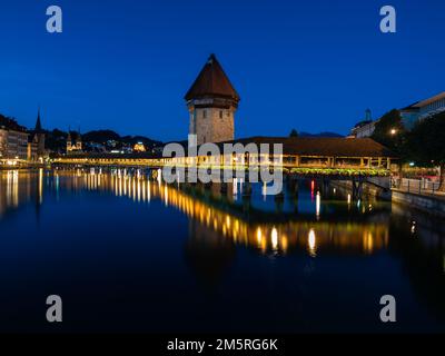 Image of Lucerne, Switzerland, with the famous historical wooden Chapel bridge, during twilight blue hour. Stock Photo