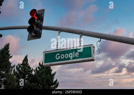 Google text signage hanging by traffic signal with sky in background Stock Photo