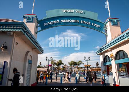 People at entrance of Santa Cruz Beach Boardwalk with under blue sky Stock Photo