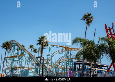 Colorful roller coaster tracks and palm trees at Santa Cruz Beach Boardwalk Stock Photo