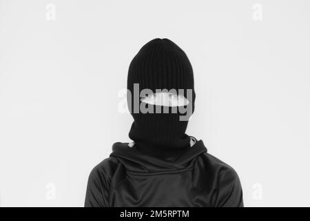 Hat balaclava on a girl on a white background, the face of a thief in hats with a slit for verbs Stock Photo