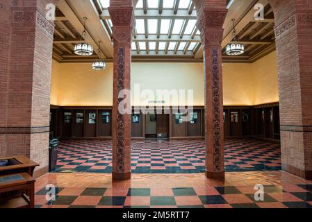 Chandeliers hanging on ceiling over tiled floor inside the college of UCLA Stock Photo