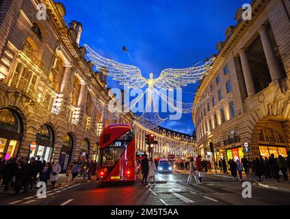 People and traffic along Regent Street in London, UK. Evening view of Regent Street with Christmas lights above the road Stock Photo