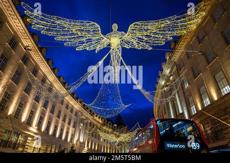 Architecture along Regent Street in London, UK. Evening view of Regent Street with Christmas lights above the road and red London bus Stock Photo