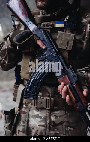 A soldier is holding an assault rifle, close-up. Stock Photo