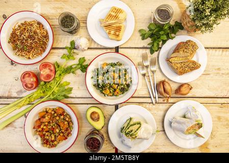 Healthy food snacks and plates set with vegan salads, snacks with spinach and seeds and lots of fresh fruits and vegetables Stock Photo