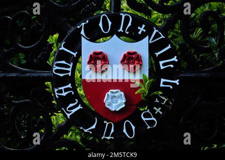 Southampton city crest on a gate in front of bright green bush Stock Photo