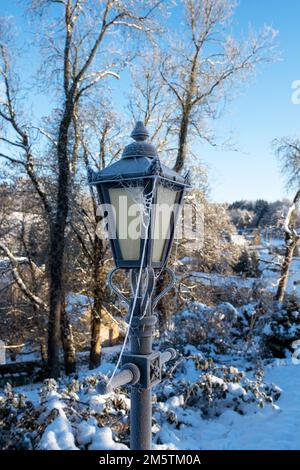 Icy lamp post in St Oswald's churchyard. Compton Abdale, Cotswolds, Gloucestershire, England Stock Photo