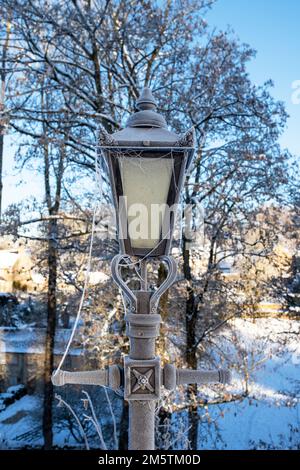 Icy lamp post in St Oswald's churchyard. Compton Abdale, Cotswolds, Gloucestershire, England Stock Photo