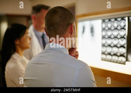 Analyzing the internal parts of the body. a team of surgeons discussing a patients medical scans. Stock Photo