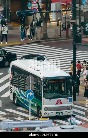 Public Vehicles driving through the Shibuya intersection Stock Photo