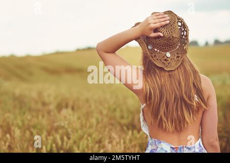The best way to explore is by foot. Rearview shot of a young woman spending time in the countryside. Stock Photo