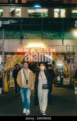 Train passes above a pedestrian tunnel in Shibuya Stock Photo