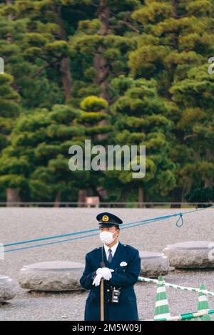 A security officer wearing a mask on duty at the entrance of Tokyo Imperial Palace Stock Photo