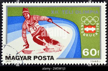 Cancelled postage stamp printed by Hungary, that shows Slalom Skiing, promoting Winter Olympics in Innsbruck, circa 1975. Stock Photo