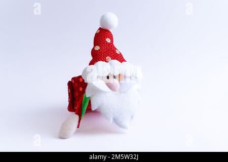 Plush red Santa Claus on a white background. Season of celebration. Stock Photo