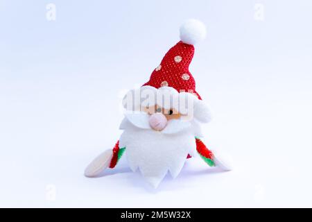 Plush red Santa Claus on a white background. Season of celebration. Stock Photo