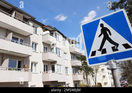 Close-up of crosswalk sign outside multi-family houses. Stock Photo
