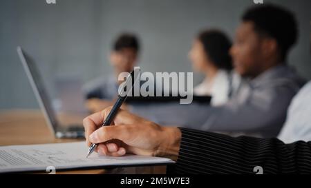 Close-up female hand writing notes on paper signing document contract unrecognizable businesswoman write financial report in office on blurred Stock Photo