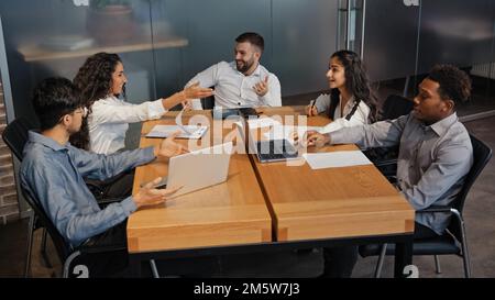 Successful multiethnic colleagues discussing idea project in office boardroom meeting. Multiracial business team group of people discuss talking Stock Photo
