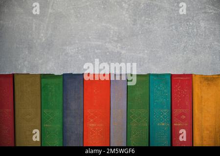 Home library of old battered retro books with colored spines Stock Photo