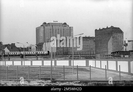 GDR, Berlin, 23. 02. 1990, Spreebogen, view across the Spree to the Wall on the east side, Charite high-rise, passenger train Stock Photo