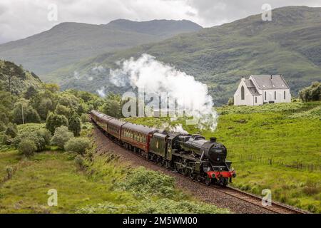 BR 4-6-0 5MT No. 45407 'The Lancashire Fusilier' passes Our Lady of the Braes Chapel, Polnish, Lochailort, Highland, Scotland, UK Stock Photo