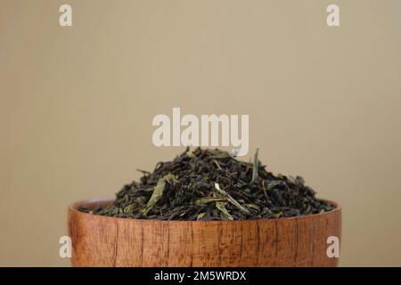 Black Dry Tea Pouring in a Bowl. Pile of Mix Black and Green Tea Leaves. Close Up, Macro. Front View. Texture. Copy Space. Dried Tea is Spinning, Rota Stock Photo