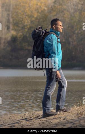 Portrait of traveler man at lake in autumn. High quality photo Stock Photo