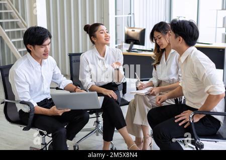Group of business people sitting on chairs in support group circle and sharing idea on team building Stock Photo