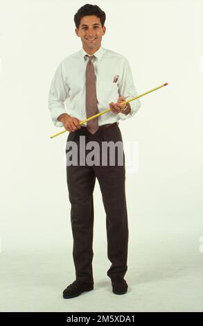 Full figure view of man, standing holding a pointer stick, smiling at the camera Stock Photo