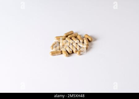 Vitamin K pills scattered on white background. Drug capsule pills with beige medication. Stock Photo