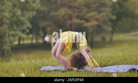 Beautiful little girl gymnast performs in competitions Stock Photo