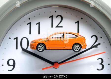 MODEL CAR ON CLOCK FACE RE MOTORISTS CARS ELECTRIC DIESEL PETROL HYBRID SCRAP TIME RUNNING OUT COSTS REPAIRS SECOND HAND CAR BUYERS ETC UK Stock Photo