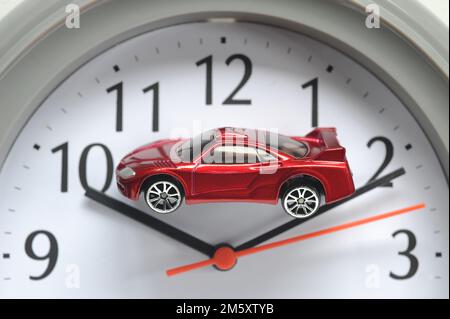 MODEL CAR ON CLOCK FACE RE MOTORISTS CARS ELECTRIC DIESEL PETROL HYBRID SCRAP TIME RUNNING OUT COSTS REPAIRS SECOND HAND CAR BUYERS ETC UK Stock Photo