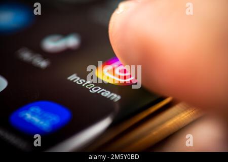 London. UK- 12.31.2022. A person pressing the icon for the social media messaging application Instagram on a cellphone. Stock Photo