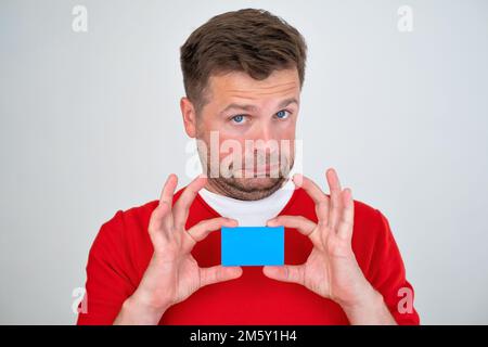 man looking displeased holding credit card in hands Stock Photo