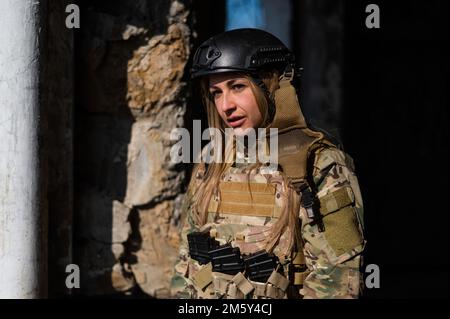 Portrait of a caucasian woman in a protective suit. Female FA soldier in camouflage uniform. Stock Photo