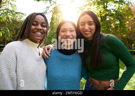 Portrait of three girls outside looking at the camera. Friendship in multi-ethnic groups of people Stock Photo